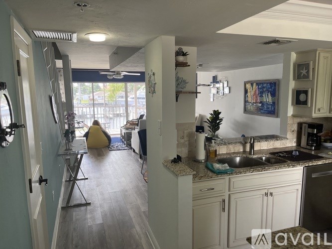 A kitchen with a sink, a fridge, and a window.