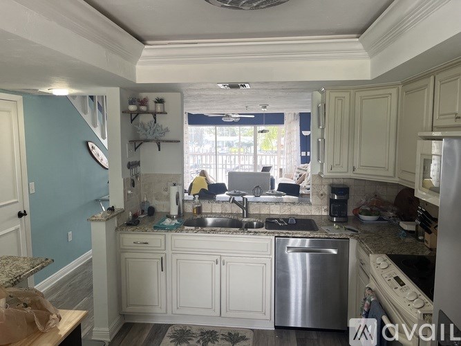 A kitchen with a blue wall and white cabinets.