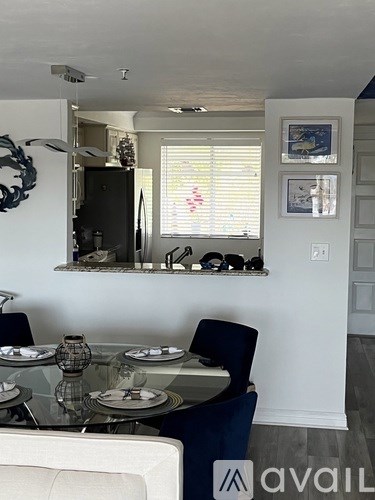 A dining room with a glass table and chairs.