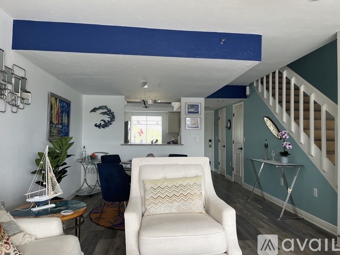 A living room with a white chair and a blue ceiling.