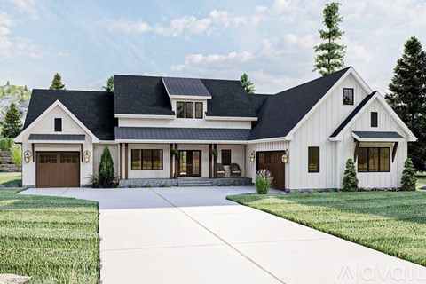 A large white house with a black roof and a garage door.