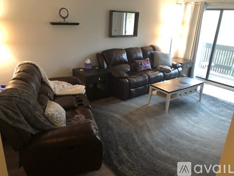 A living room with a brown leather couch and a small table.
