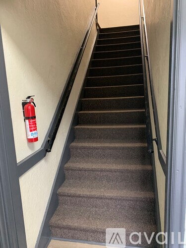 A staircase with a fire extinguisher on the wall.
