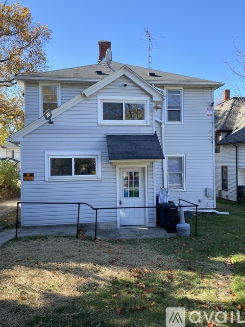 A two-story house with a white door and a black awning.