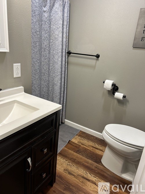 A white toilet sits next to a white sink in a bathroom.