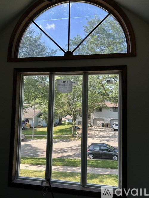 A window with a view of a street and houses.