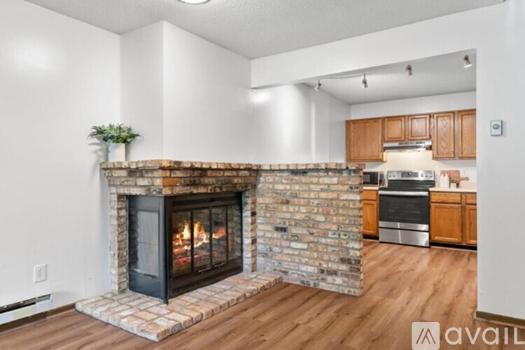 A room with wooden flooring and a fireplace.
