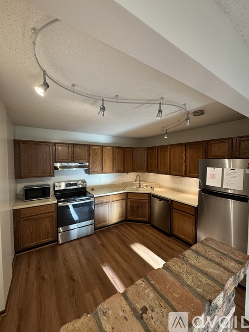 A kitchen with wooden cabinets and stainless steel appliances.
