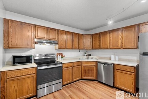 A kitchen with wooden cabinets and stainless steel appliances.
