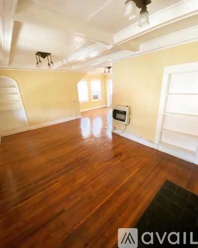 A room with wooden floors and a ceiling fan.