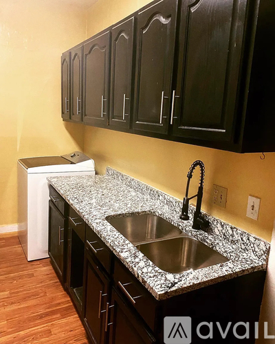A kitchen with black cabinets and a granite countertop.