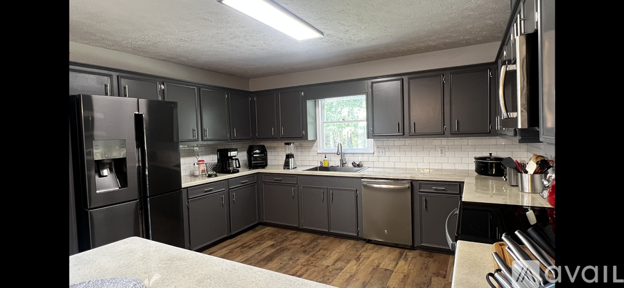A kitchen with black cabinets and a white fridge.