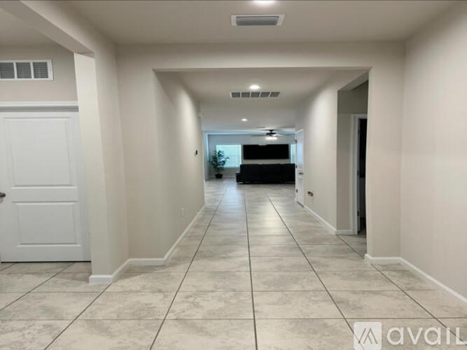 A long hallway with a white door on the left and a black door on the right.