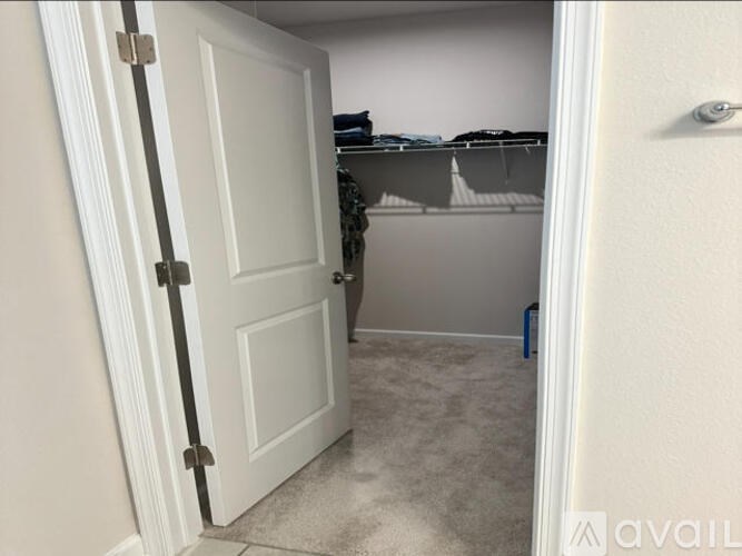 A white door with a black handle is open.