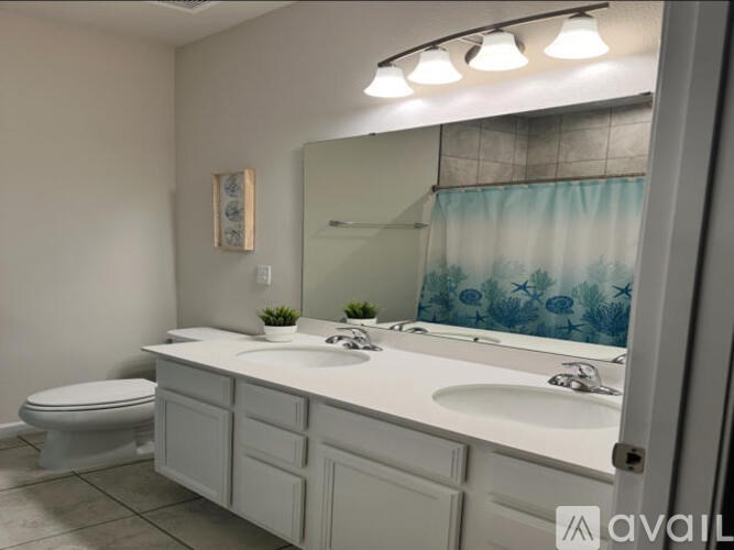 A bathroom with a toilet, sink, and mirror.