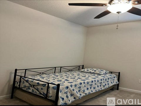 A bedroom with a bed and a ceiling fan.
