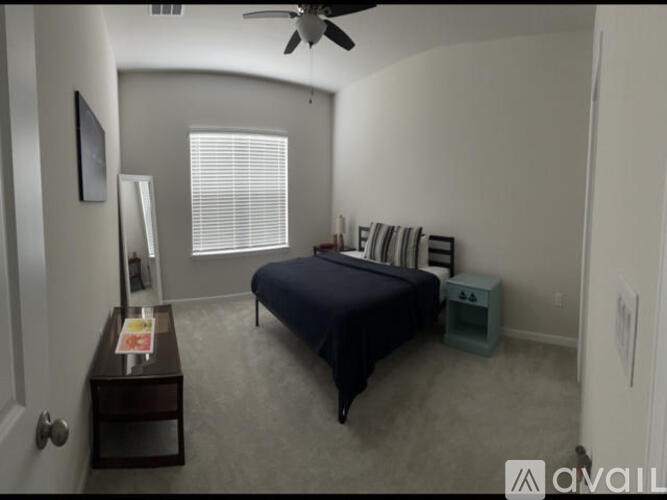 A bedroom with a bed, nightstand, and a fan.
