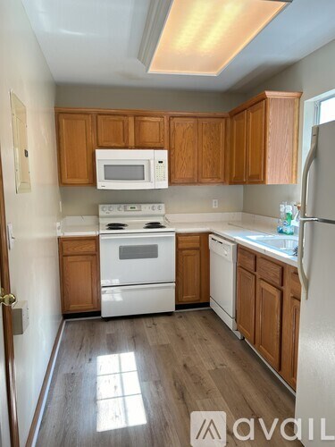 A kitchen with wooden cabinets and white appliances.