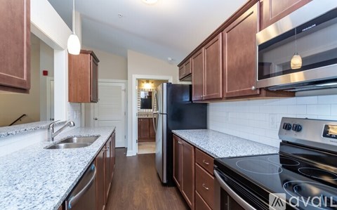A kitchen with brown cabinets and a granite countertop.