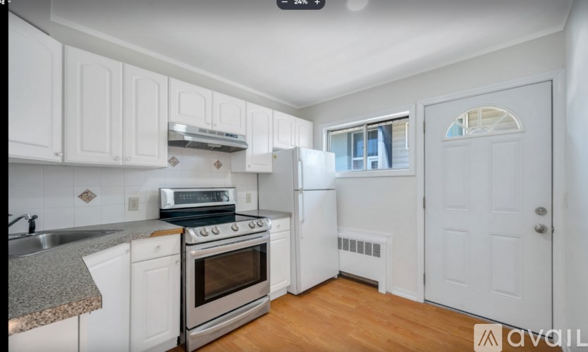 A kitchen with white cabinets and a stove top oven.