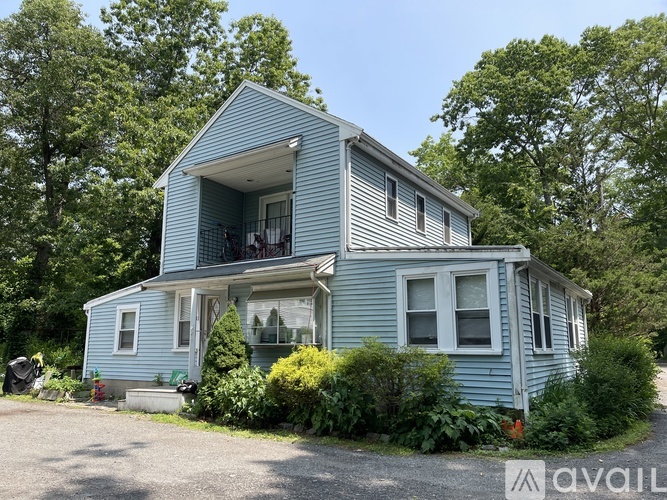 A blue house with a porch and a white door.