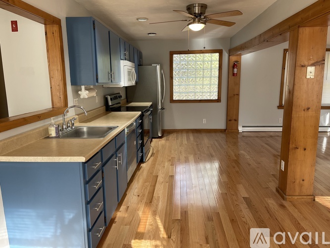 A kitchen with blue cabinets and a wooden floor.