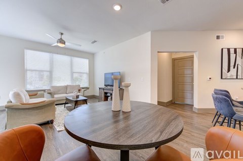A living room with a brown table and orange chairs.