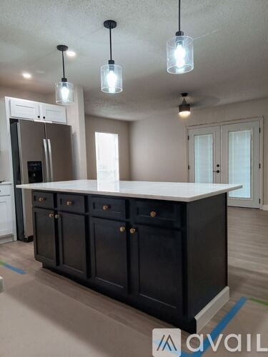 A kitchen with a black cabinet and a white countertop.
