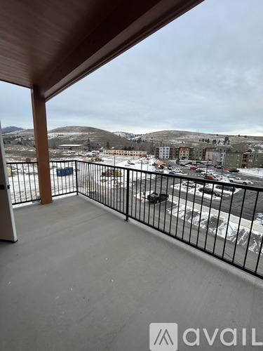 A balcony with a view of a snowy landscape and buildings.