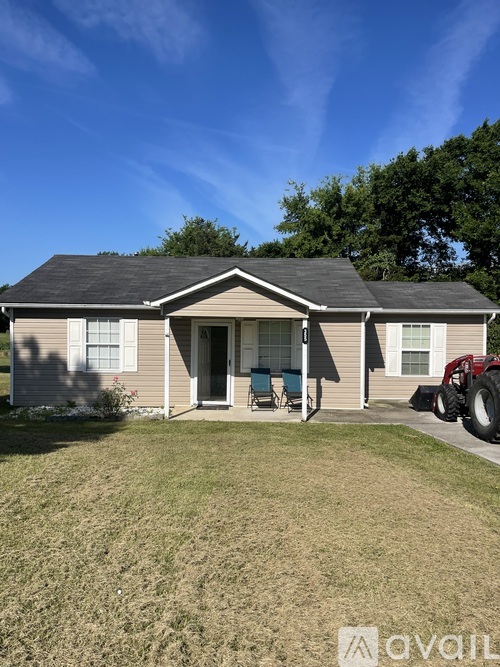 A house with a tractor in front of it.