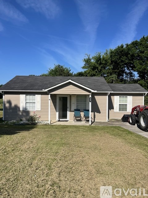 A house with a tractor in front of it.