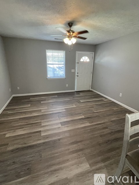 A room with wooden flooring and a ceiling fan.