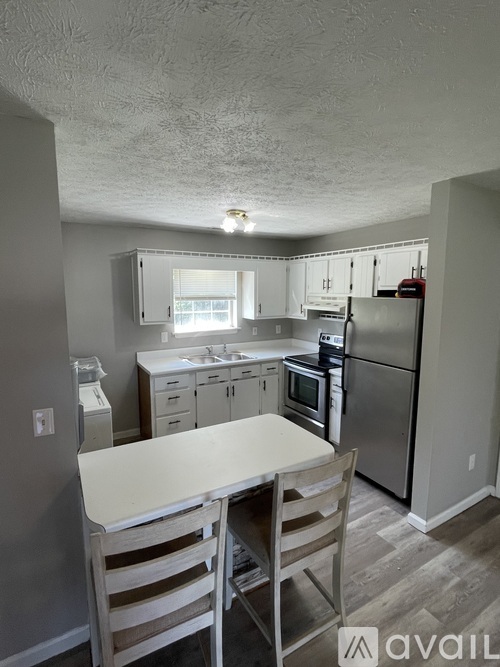 A kitchen with a table and chairs in the foreground.