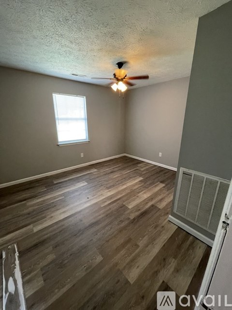 A room with wooden flooring and a ceiling fan.