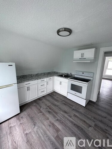 A kitchen with white appliances and cabinets.