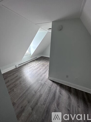 A room with wooden flooring and a skylight.