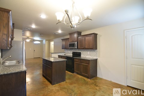 A kitchen with brown cabinets and a chandelier.