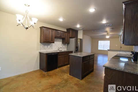 A kitchen with brown cabinets and a granite countertop.