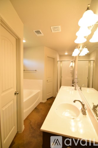 A bathroom with a white counter top and a white sink.