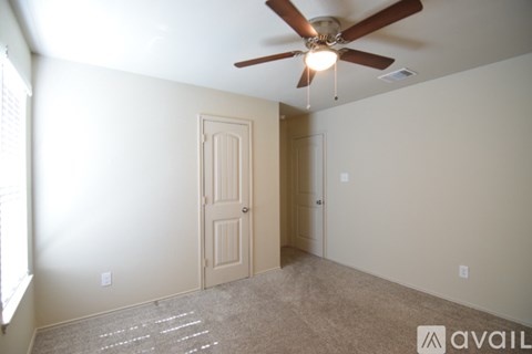 A room with a ceiling fan and two doors.