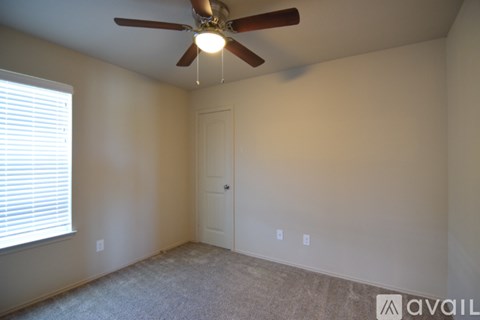 A room with a ceiling fan and a door.