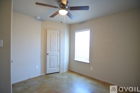 A room with a ceiling fan and a door.