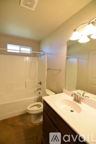 A bathroom with a toilet, sink, and mirror.