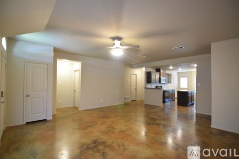 A large empty room with a fan on the ceiling.