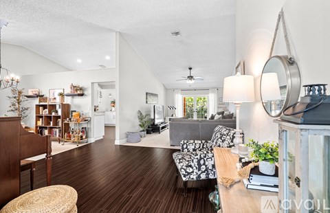 A living room with a grey couch and a wooden floor.
