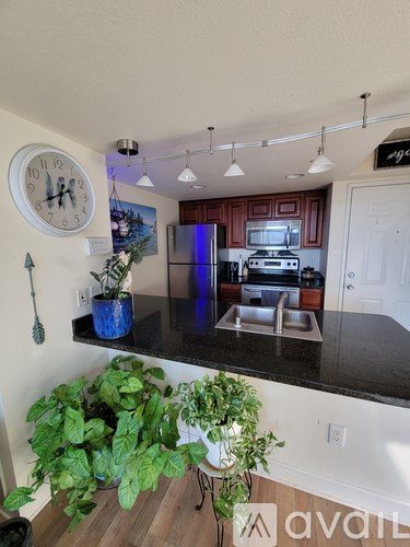 A kitchen with a black counter top and a blue pot on it.