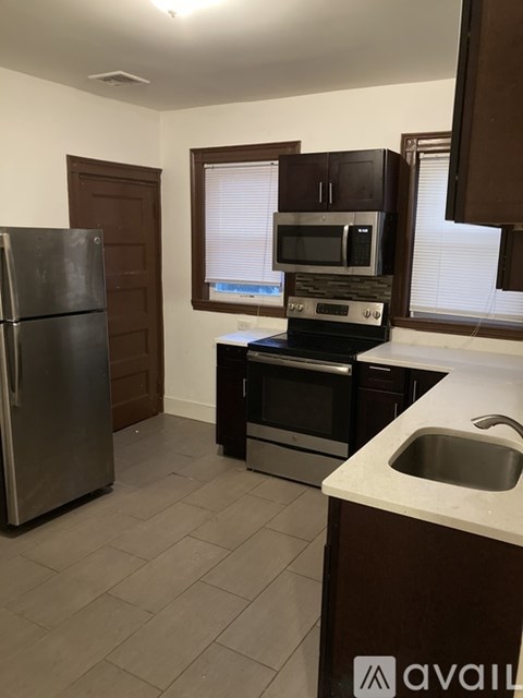 A kitchen with a stainless steel refrigerator and a stove top oven.