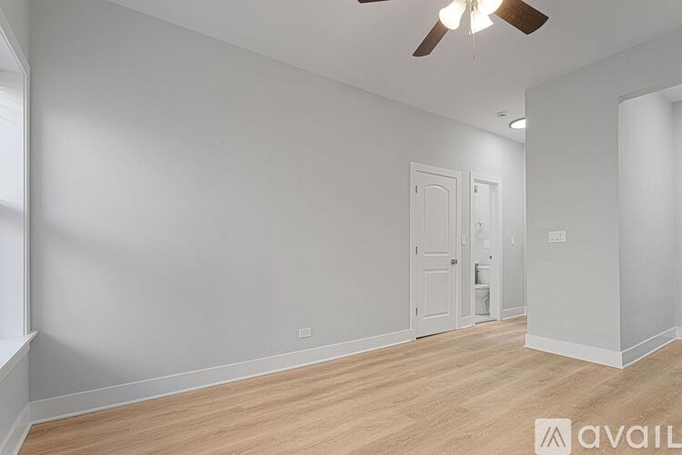 A room with a ceiling fan and two doors.