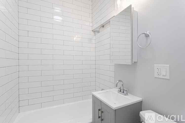 A white bathroom with a white sink and a white tub.