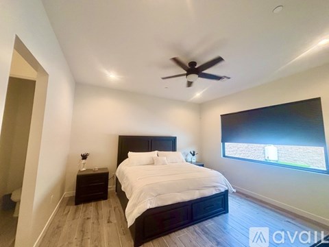 A bedroom with a large bed and a ceiling fan.